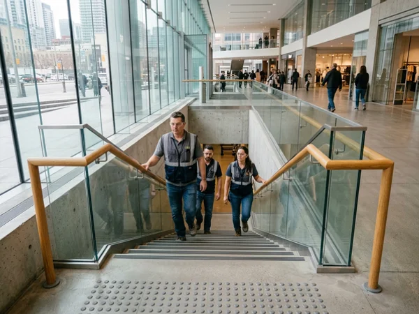 Retail egress stair with 300mm handrail extensions and tactile indicators in Concord